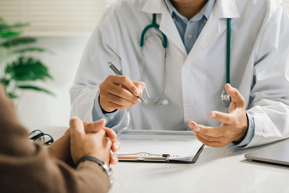A physician in a white medical uniform talks to patient about her options