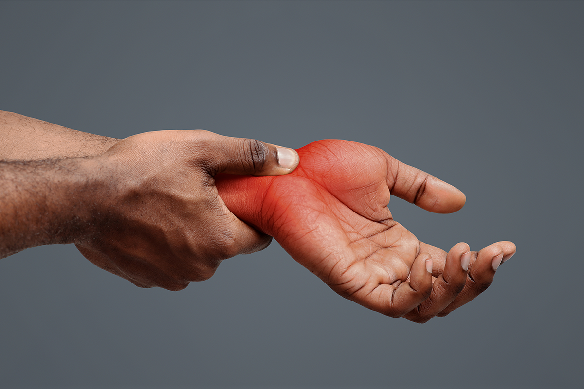 Black guy massaging painful wrist because of carpal tunnel syndrome