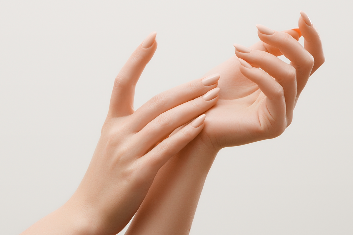 Closeup image of beautiful woman's hands with light pink manicure on the nails