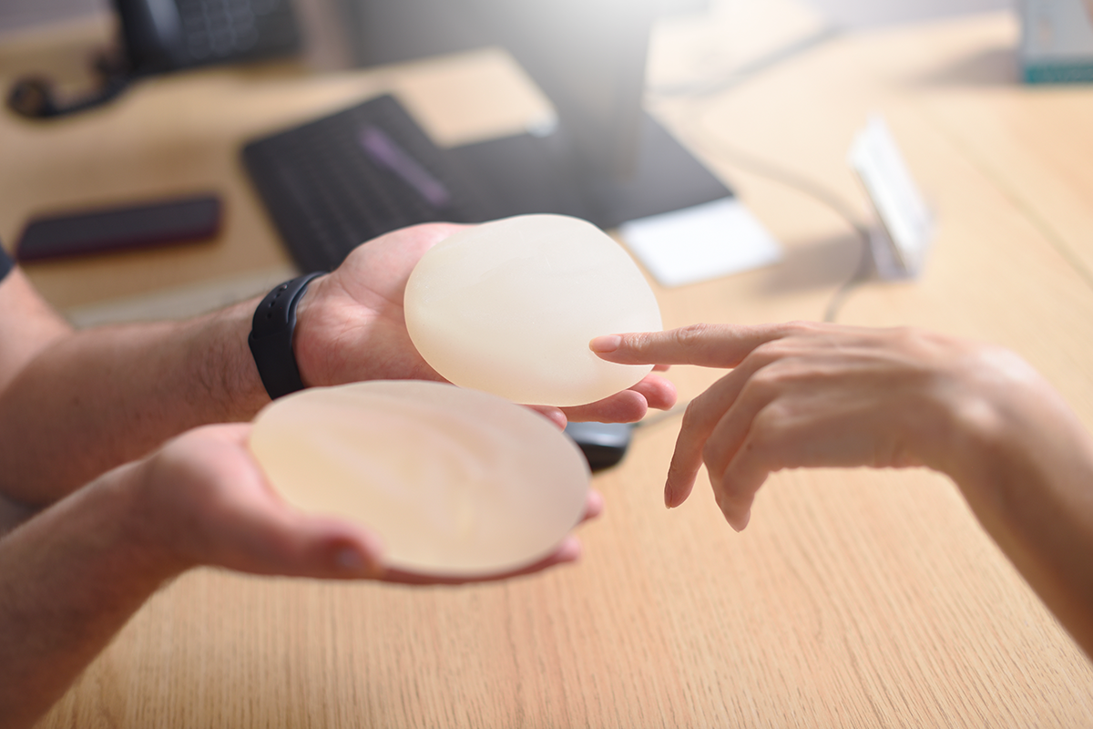 Female hand picks silicone implants for breast augmentation